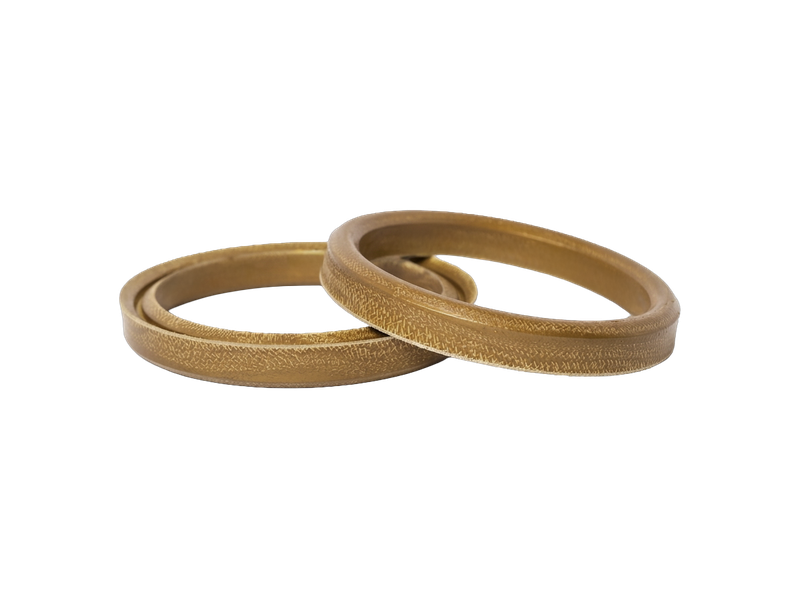 A pair of WSP Extreme® Gold well service packing rings, showing the fabric-reinforced sealing face.